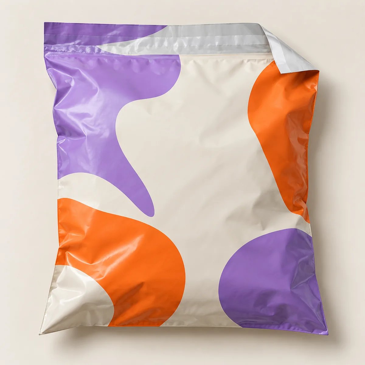 Konzept einer glänzenden, flexiblen Folien-Versandtasche mit großen Farbflächen in Flieder und Orange.